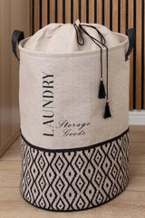 Krem siyah desenli, kordelalı depo ve çamaşır sepeti, ahşap zemin ve duvar önünde
