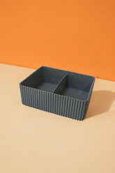 İki bölmeli gri dalgalı plastik saklama kutusu üzerinde turuncu ve bej zemin