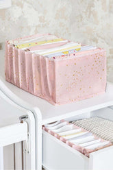 Pembe yıldız desenli kumaş düzenleyicide katlanmış bebek kıyafetleri ve çekmece içi düzenleme