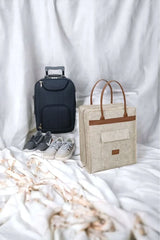 Beyaz fon önünde siyah çekçekli valiz, bej renkli el çantası ve Nike spor ayakkabılar