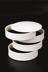 Beyaz üst üste dizilmiş, yuvarlak plastik saklama kutuları siyah arka planda