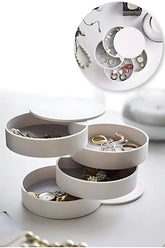 Beyaz katlanabilir takı kutusunda yüzükler, saatler ve inci kolye düzenlemesi