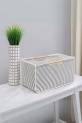 Gri beyaz çizgili kumaş sepet ve dekoratif yapay bitki beyaz masada