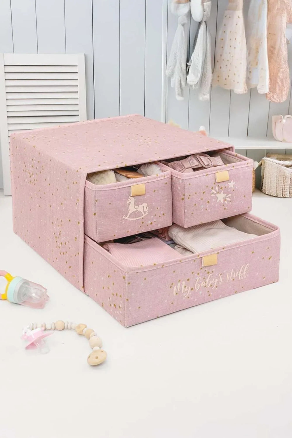 Pembe desenli bebek kıyafetleri için üç bölmeli saklama kutusu ve yerde emzikli oyuncak