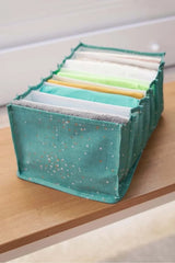 Yıldız desenli yeşil kumaşlı bölmeli organizer içinde katlanmış renkli bezler