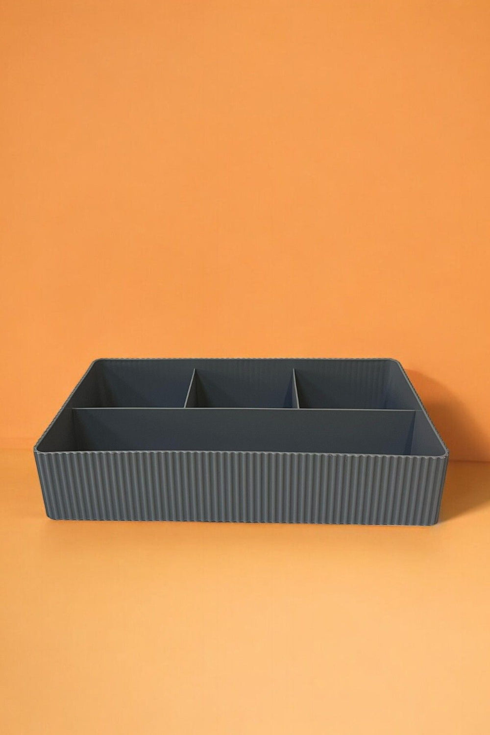 Gri renkli bölmeli plastik organizasyon kutusu turuncu arka planda