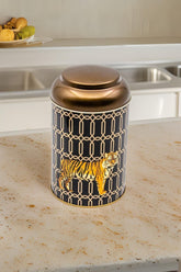 Kaplan desenli siyah ve altın renkli metal baharat kutusu mutfak tezgahında