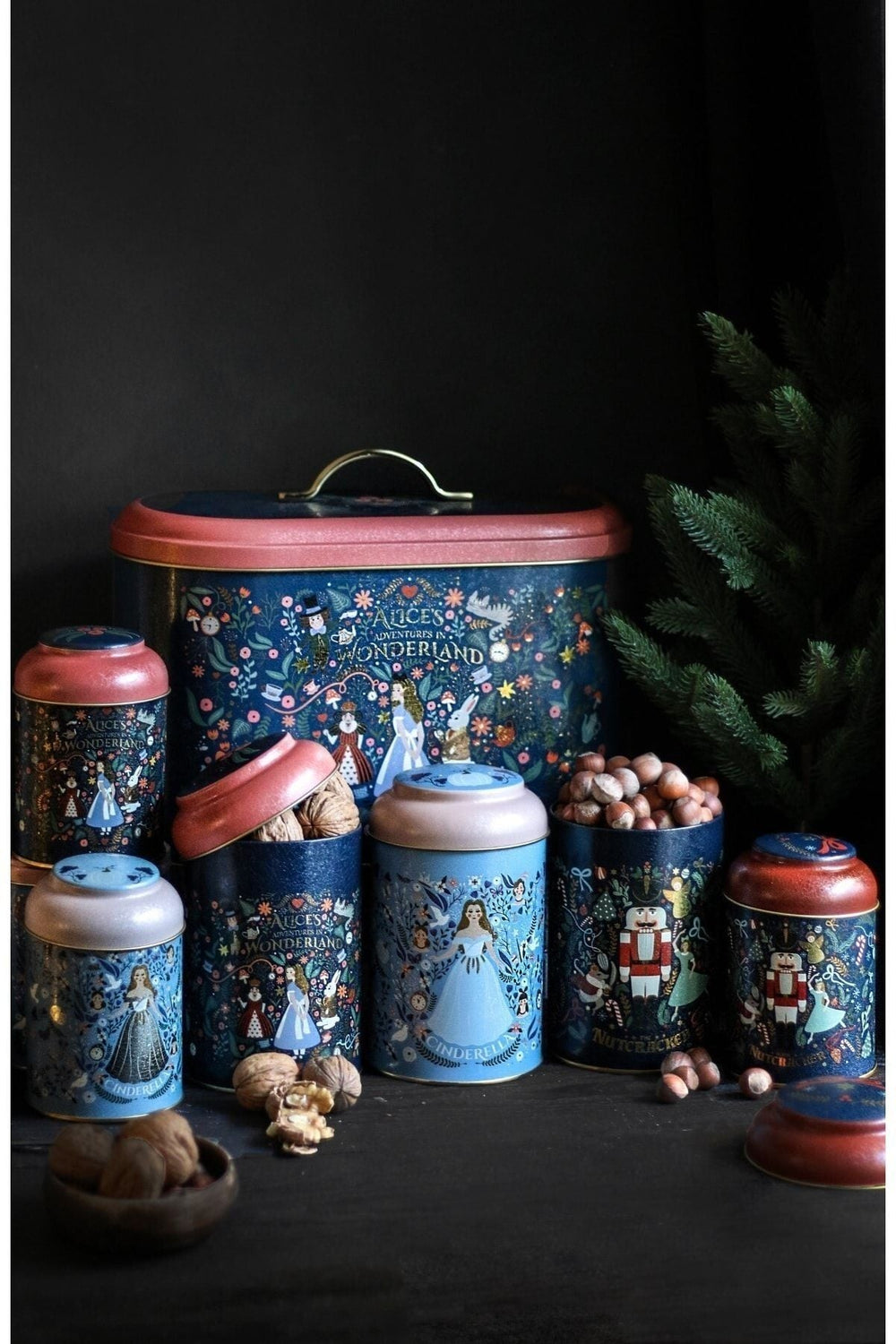 Alice's Adventures in Wonderland temalı dekoratif metal kutular, içinde kuruyemişlerle siyah zeminde