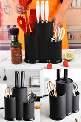 Siyah çoklu mutfak araç gereçleri düzenleyici, beyaz saplı bıçaklar, makas, kırmızı mutfak spatulaları ve turuncu önlük