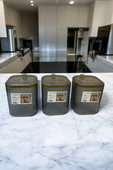 Mutfak tezgahında üç adet şeffaf Duoline saklama kabı, kare ve koyu renkli kapaklı