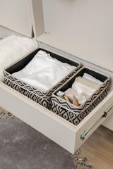 Desenli kumaş saklama kutularında beyaz ve bej kumaşlar, çekmecede düzenli kıyafet ve aksesuarlar