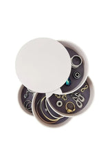 Beyaz çok katmanlı yuvarlak takı kutusunda çeşitli altın ve gümüş takılar