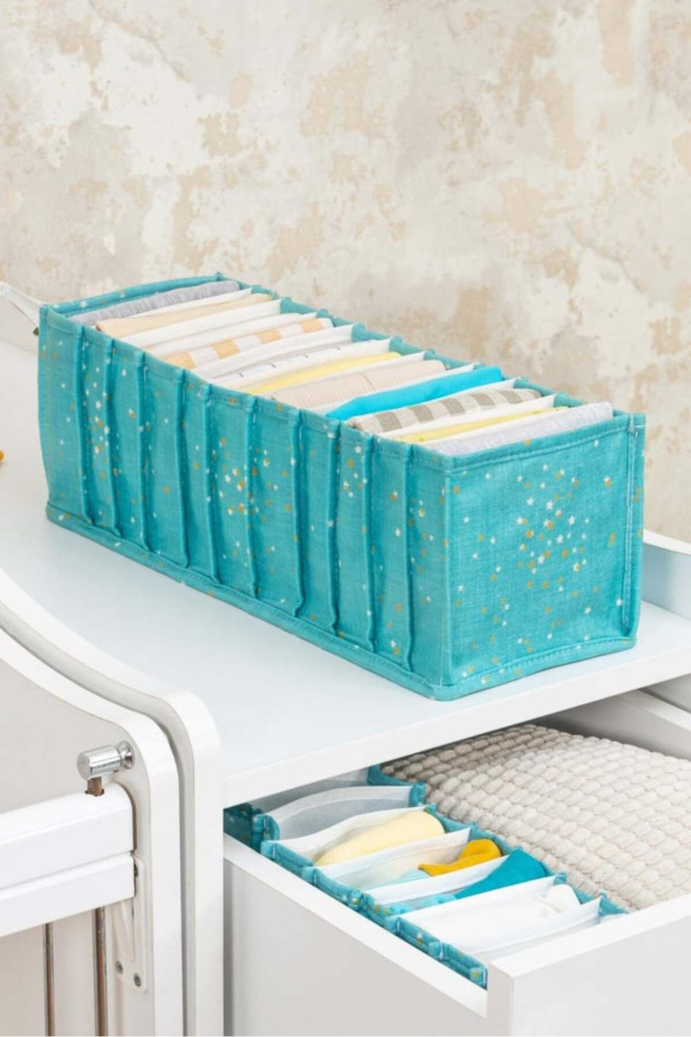 Mavi desenli kumaş düzenleyici içinde düzenlenmiş kitaplar ve çekmecede küçük kumaş organizer