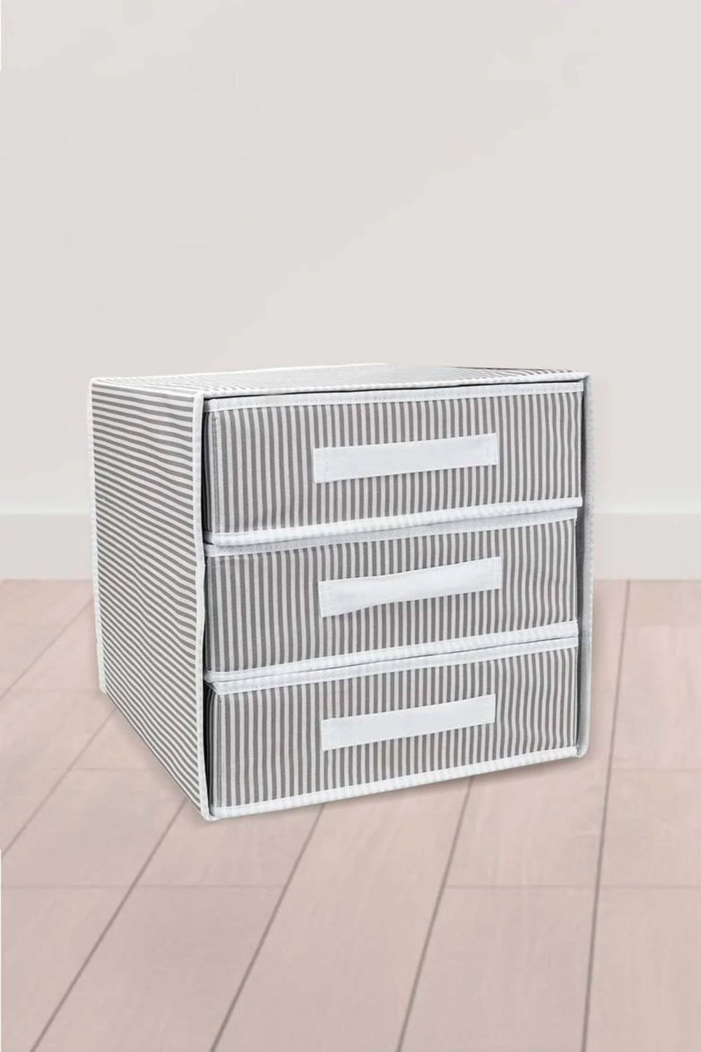 Gri beyaz çizgili üç çekmeceli kumaş saklama kutusu, açık parke zemin üzerinde