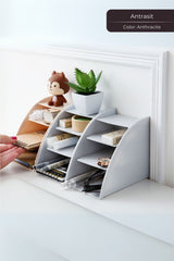 Antrasit renkli masaüstü düzenleyici, küçük dekoratif bitki ve çeşitli ofis malzemeleriyle dolu