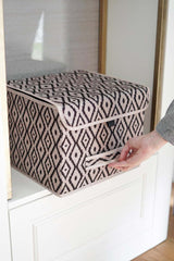 Etnik desenli siyah beyaz saklama kutusu, beyaz dolap içinde, el kutuyu tutuyor