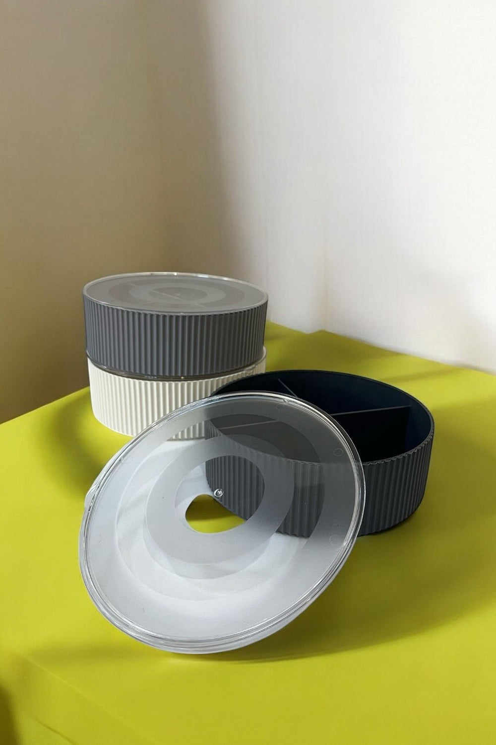 Sarı zeminde gri ve beyaz plastik bölmeli yuvarlak saklama kutuları