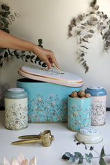 Pastel renkli, çiçek desenli metal kuruyemiş kutuları ve vintage ceviz kıracağı