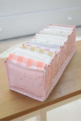 Pembe bölmeli düzenleyici içinde farklı renklerde katlanmış küçük havlular