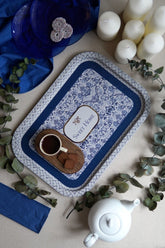 Mavi desenli Sweet Home tepsi üzerinde kahve fincanı, kurabiyeler, beyaz mumlar ve beyaz demlik ile şık çay servisi