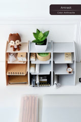 Ofis masasında kahverengi oyuncak, küçük sukulent bitkisi ve beyaz gri masaüstü düzenleyici