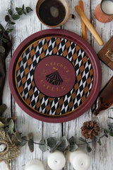 Sirkus temalı dekoratif tepsi, kahve fincanı, ekmek çubukları ve mumlarla rustik ahşap masada