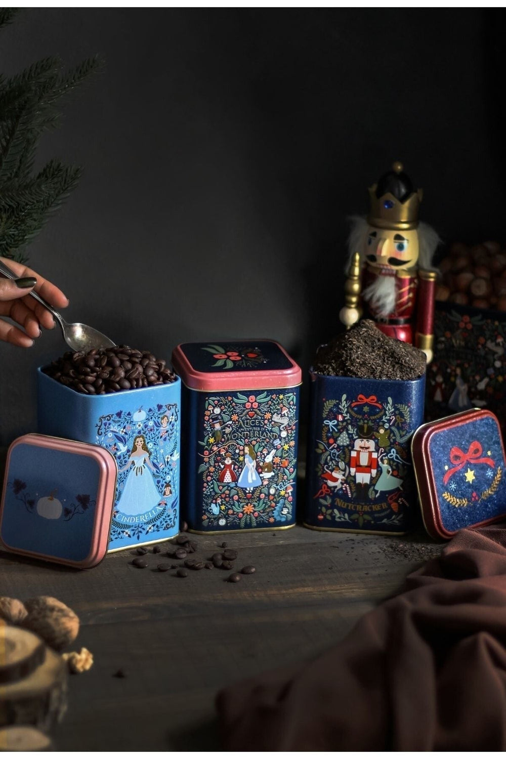 Nutcracker ve Cinderella temalı dekoratif kahve ve çay kutuları yanında ceviz ve kahve çekirdekleri