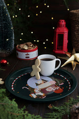 Kütük zeminde beyaz fincanda kahve, gingerbread kurabiye, Noel temalı tepsi ve kırmızı fener