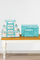 Mavi renkli bebek desenli düzenleyici kutular ve mavi fermuarlı saklama çantaları masa üstünde