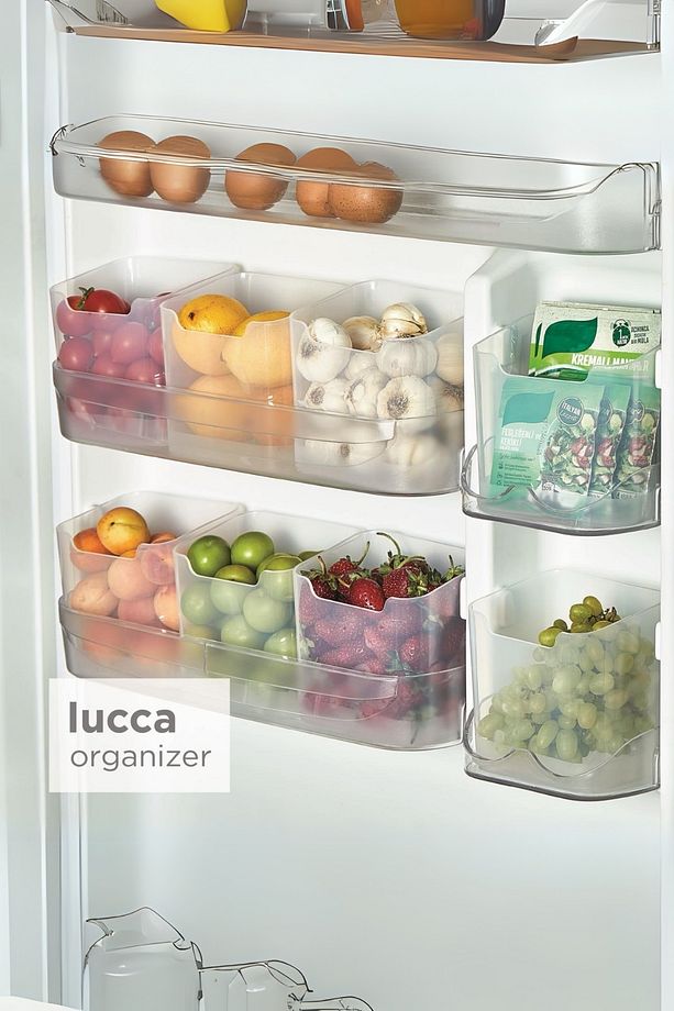 Buzdolabı kapak raflarında yumurta, domates, limon, mantar, yeşil ve kırmızı meyveler düzenleyici kutularda