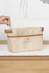 Bej renkli düzenleyici çanta içinde ruj tutan el ve beyaz mermer yüzey