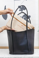 Siyah deri kadın büyük kol çantası içine krem rengi en iyi çanta astar kılıf yerleştiriliyor