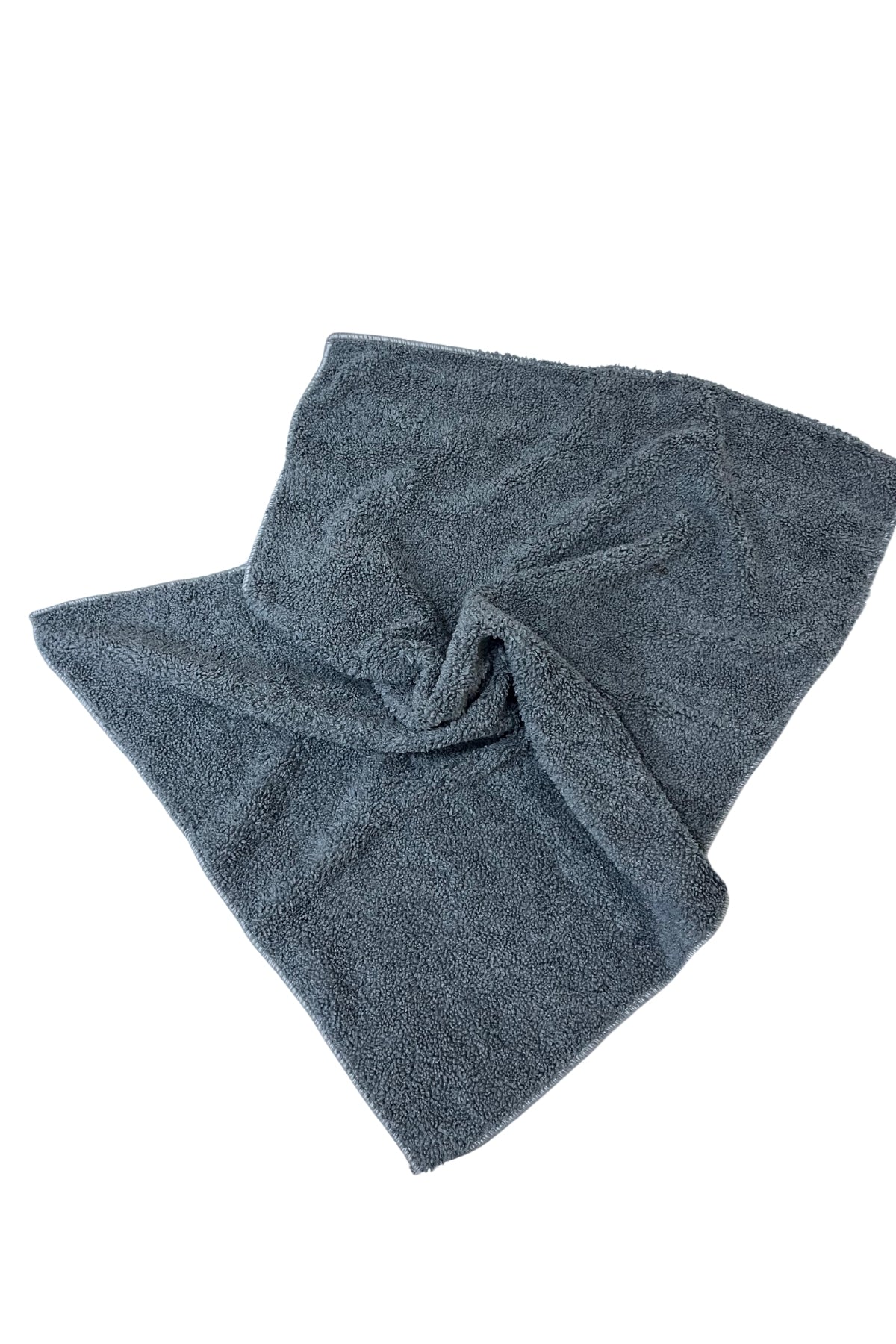 Koyu gri mikrofiber havlu, yumuşak dokulu ve büzülmüş şekilde beyaz zeminde