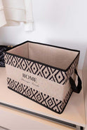 Ev depolama için siyah beyaz geometrik desenli kumaş kutu, etiketinde HOME Storage Goods yazısı
