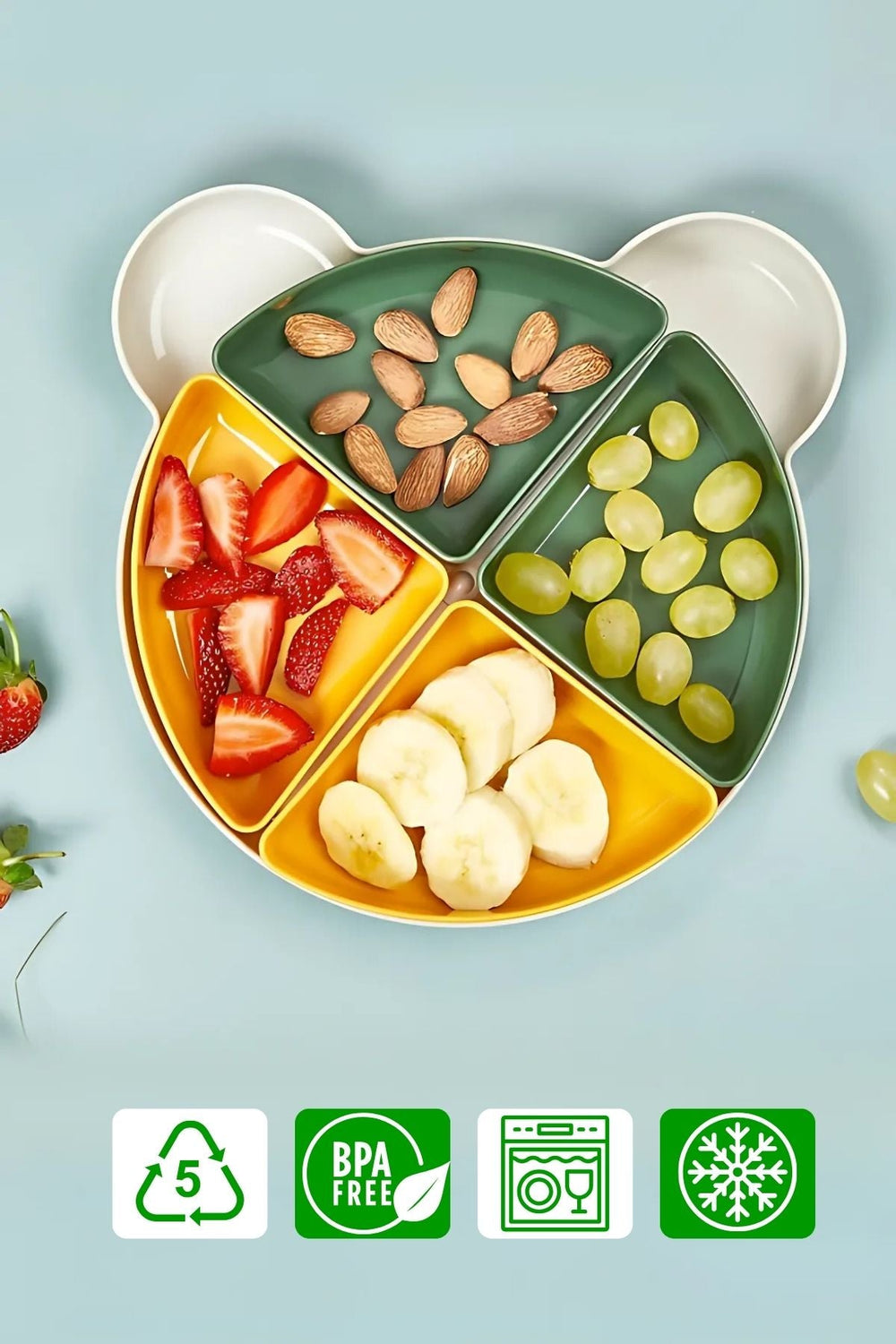 Yeşil ve sarı bölmeli masa atıştırmalık tabağında çilek, muz, üzüm ve bademler