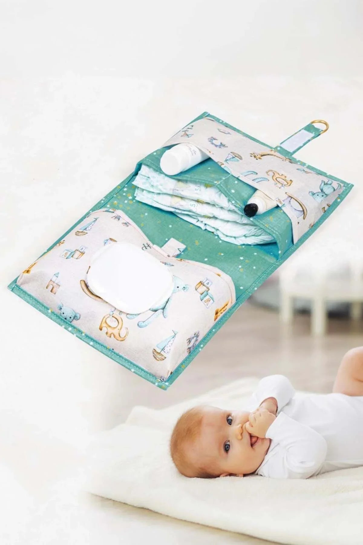 Bebek alt değiştirme çantası içinde bezler, krem ve ıslak mendil ile yerde yatıyor