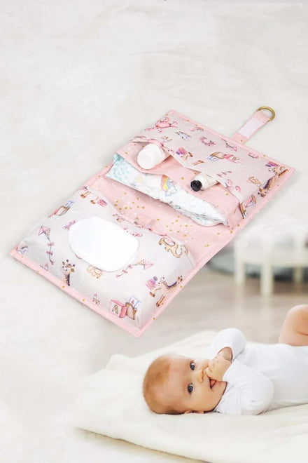 Pembe desenli bebek bakım çantası ve altında beyaz tulumlu bebek