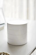 Minimalist beyaz yuvarlak kutu, modern masa üstünde, soft ışık ve dekoratif inci kolye