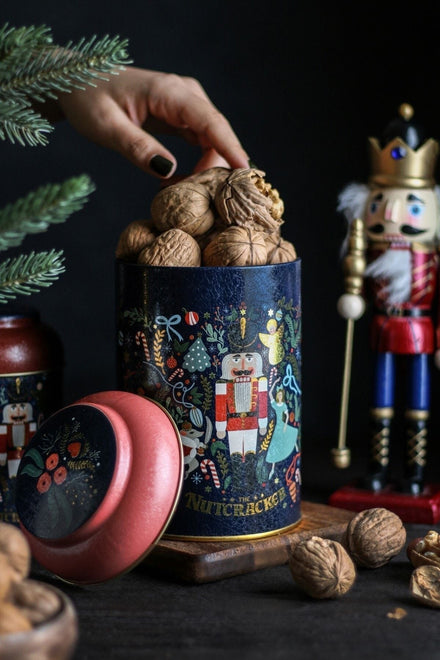 Cevizlerle dolu Nutcracker temalı kutu, yanındaki kuruyemişler ve dekoratif tahta kukla figürü