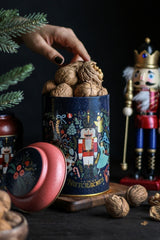 Cevizlerle dolu Nutcracker temalı kutu, yanındaki kuruyemişler ve dekoratif tahta kukla figürü