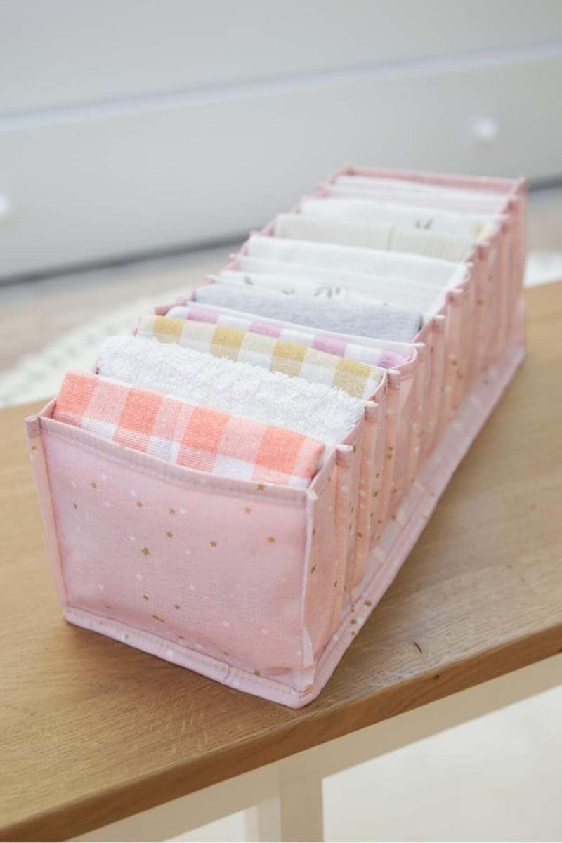 Pembe bölmeli düzenleyici içinde farklı renklerde katlanmış küçük havlular