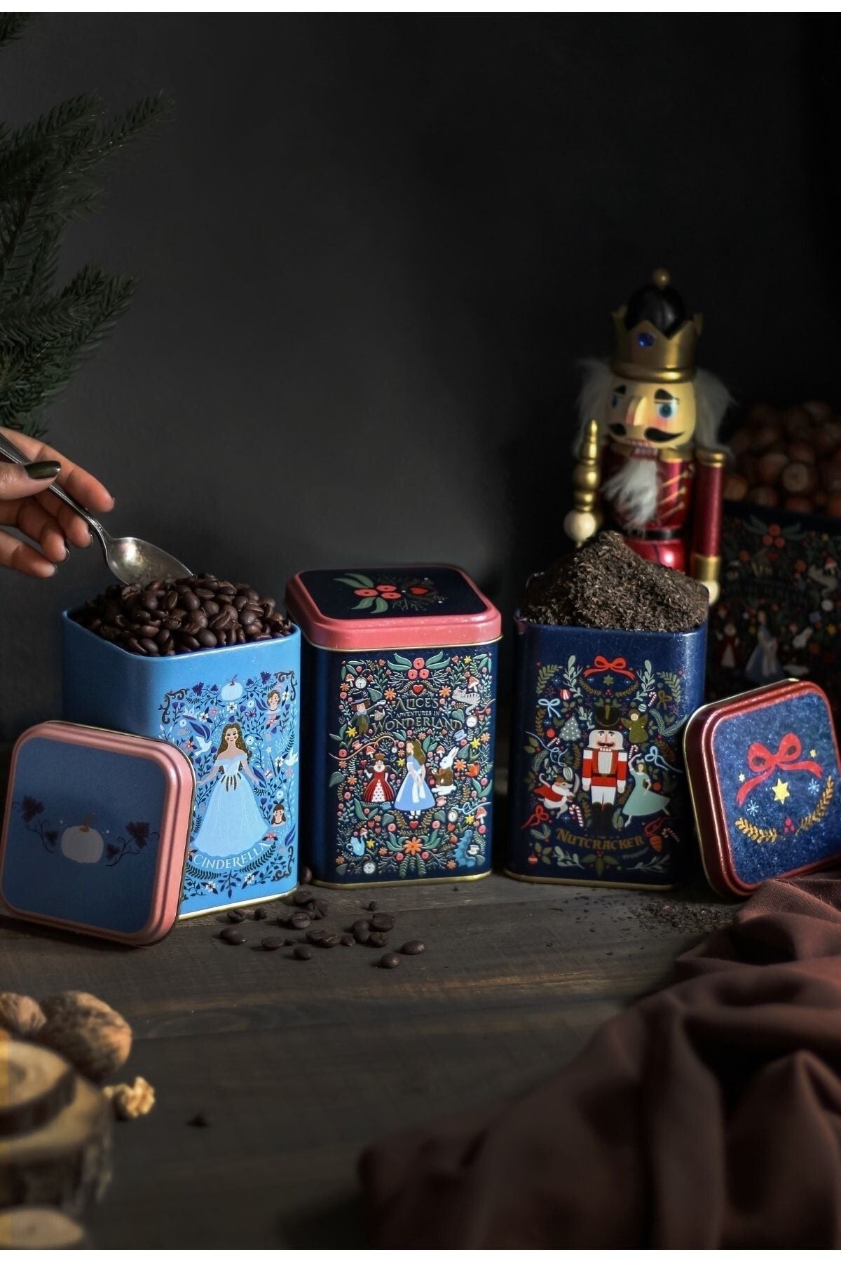 Nutcracker ve Cinderella temalı dekoratif kahve ve çay kutuları yanında ceviz ve kahve çekirdekleri