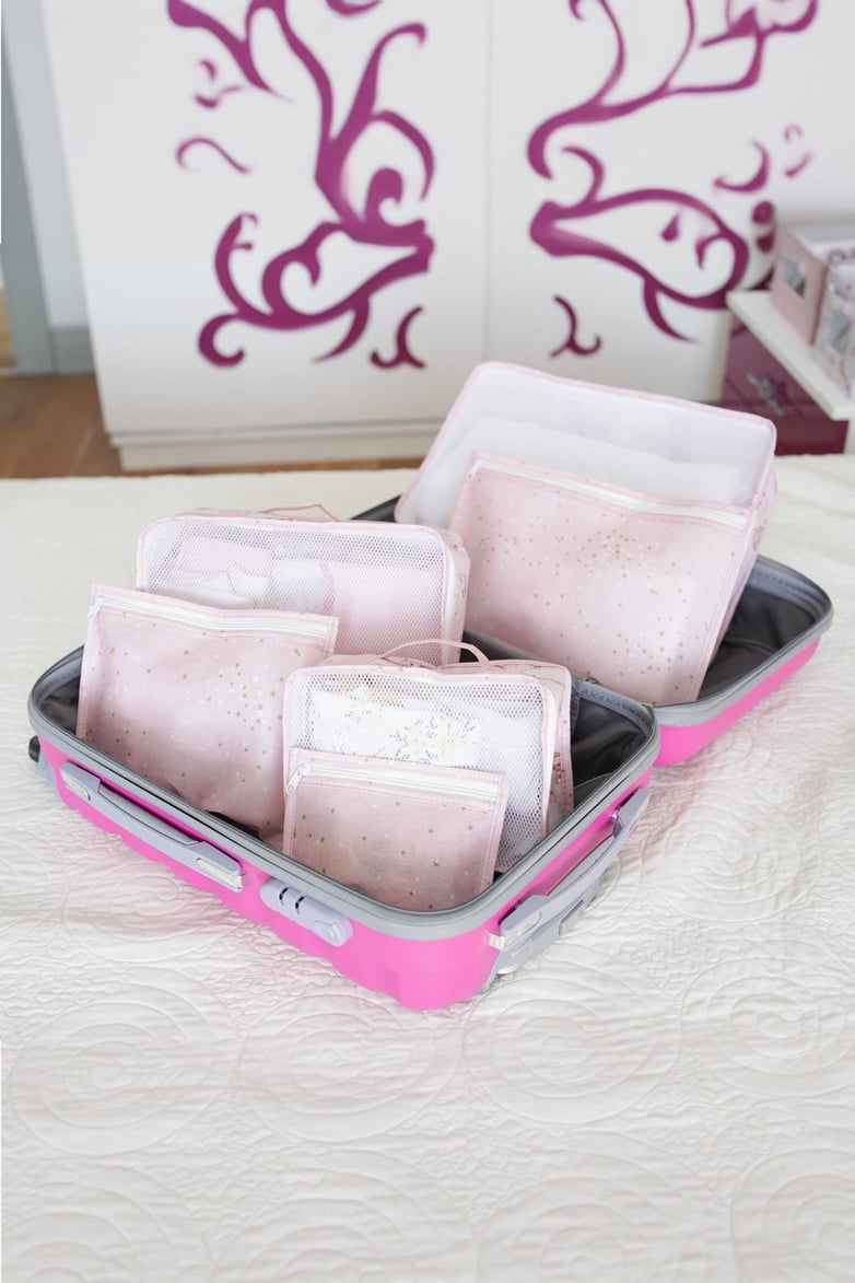 Pembe bebek seyahat seti, yıldız desenli organizer torbalar içinde açık pembe valizde