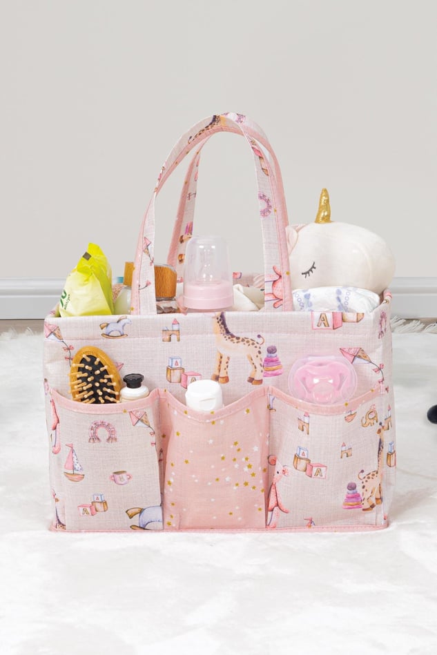 Pembe bebek bakım çantası oyuncak, biberon, emzik ve bebek bakım ürünleriyle dolu