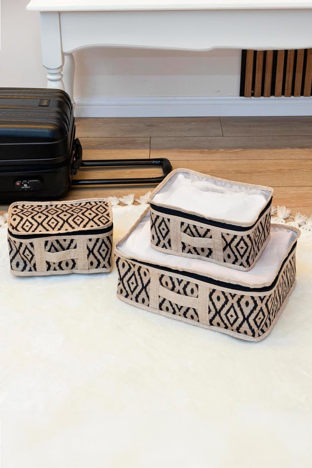 Bohem desenli üçlü seyahat çantası ve siyah kabin boy valiz, ahşap zemin üzerinde