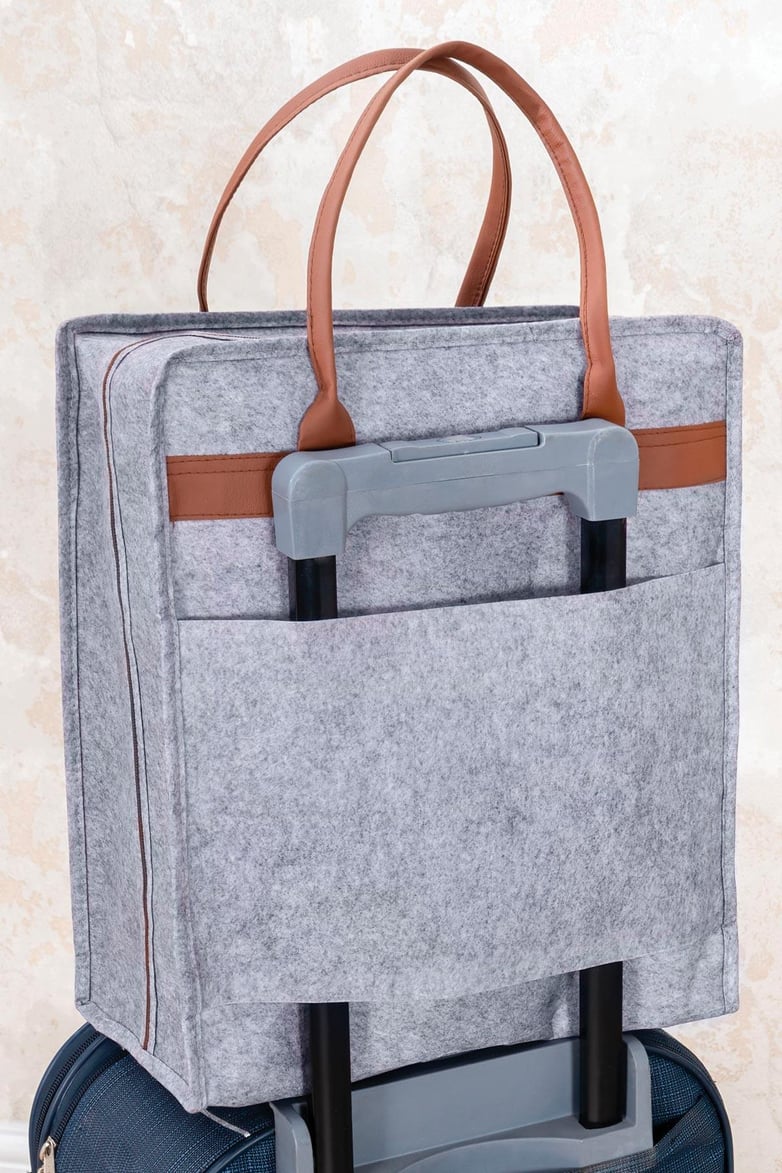 Kahverengi deri kulplu gri keçe seyahat çantası, valiz sapına takılı